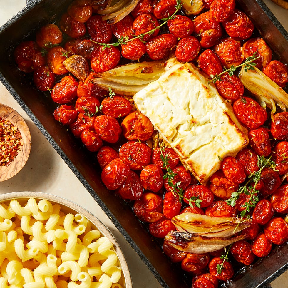 baked feta in a pan with roasted cherry tomatoes and shallots