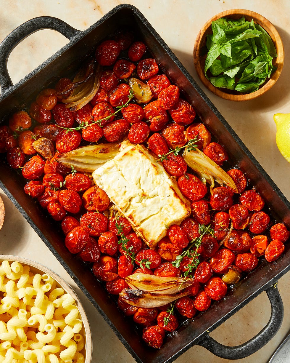 baked feta in a pan with roasted cherry tomatoes and shallots