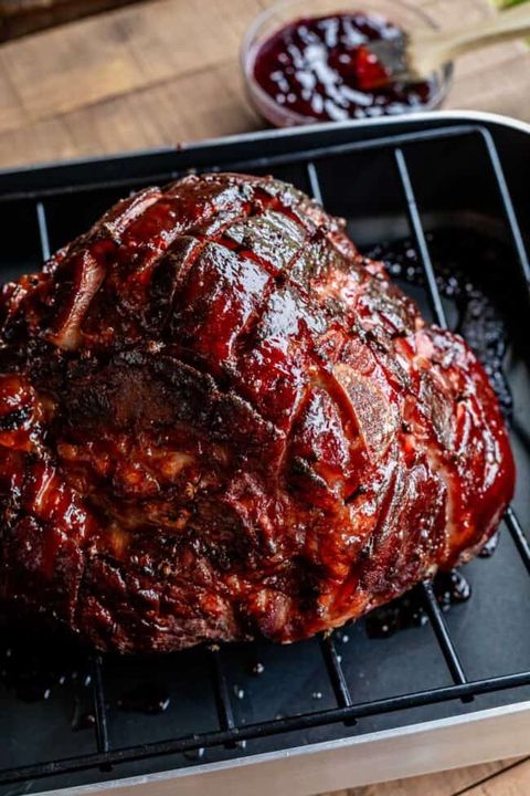 baked ham with raspberry chipotle ham glaze in a black roasting pan