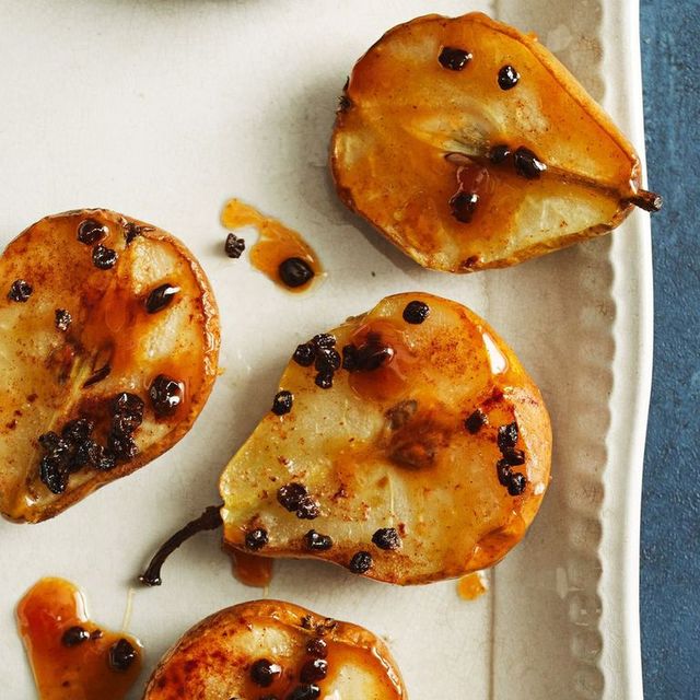 baked pear with cinnamon and currants on a white platter