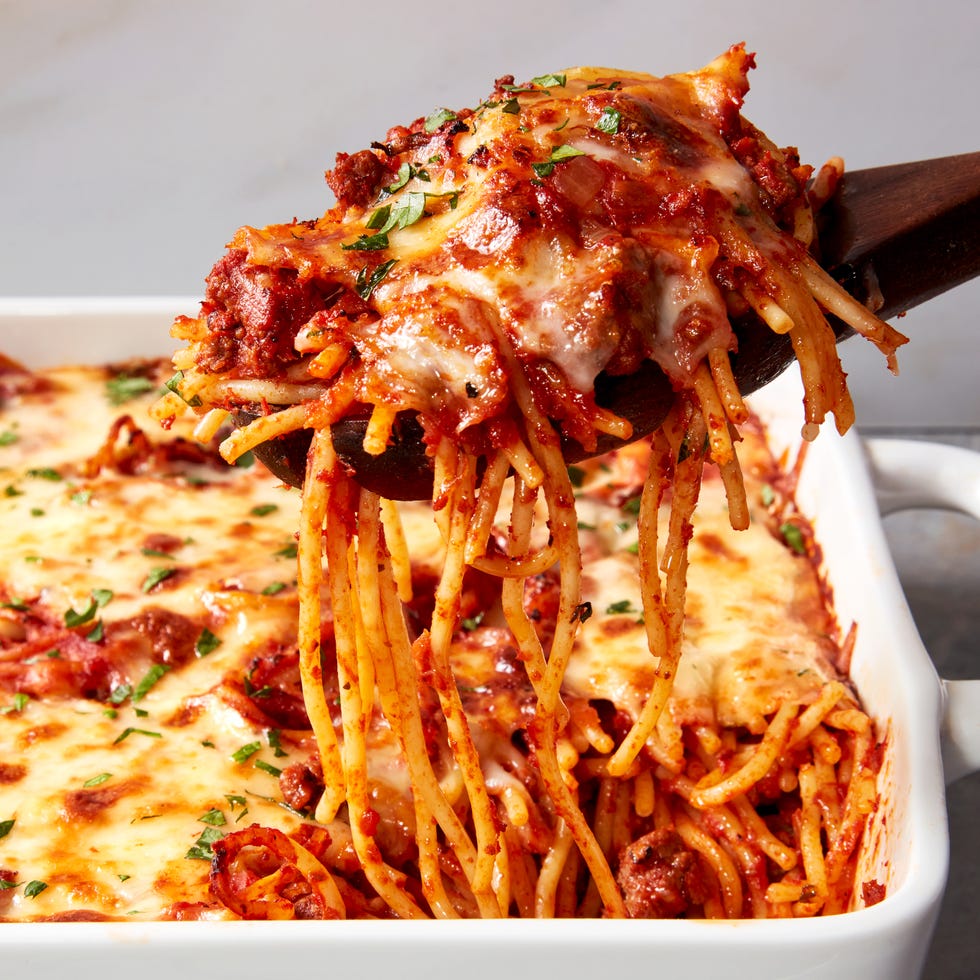 spaghetti with sauce topped with cheese baked in a casserole dish