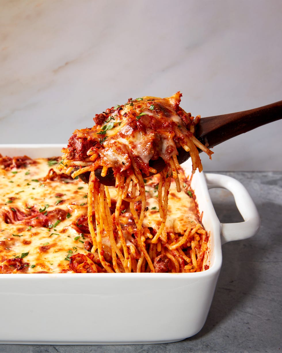 spaghetti with sauce topped with cheese baked in a casserole dish