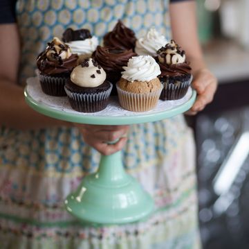 Bakery owner carrying tray of allergy-friendly cupcakes