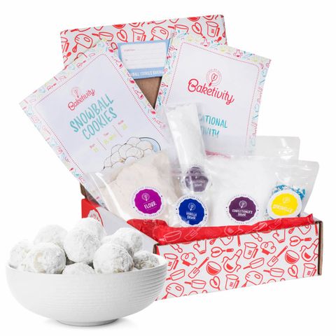 a subscription box with flour, sugar, baking instructions next to a bowl of snowball cookies