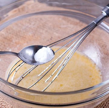 baking powder substitutes baking powder in spoon with bowl and whisk