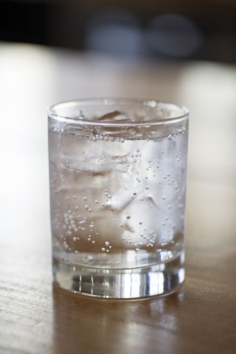 close up of carbonated water in glass on wooden table