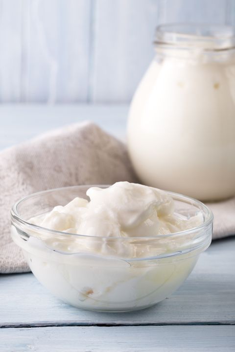 bowl of thick and creamy yogurt on light blue background