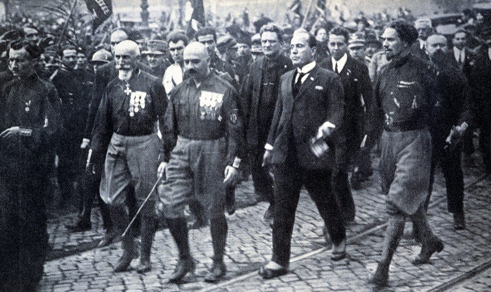 Omringd door aanhangers arriveert Mussolini in oktober 1922 in Rome Enkele dagen daarvr had de dictator de paramilitaire vleugel van zijn beweging  de Zwarthemden  opdracht gegeven de regering omver te werpen