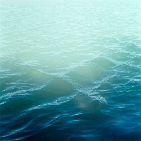 Blauwe kleurtinten glinsteren onder de oppervlakte van het meer