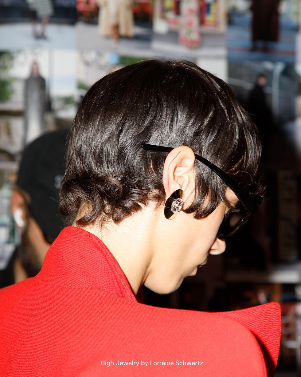 a person wearing a red garment with a high collar showcasing a sleek hairstyle
