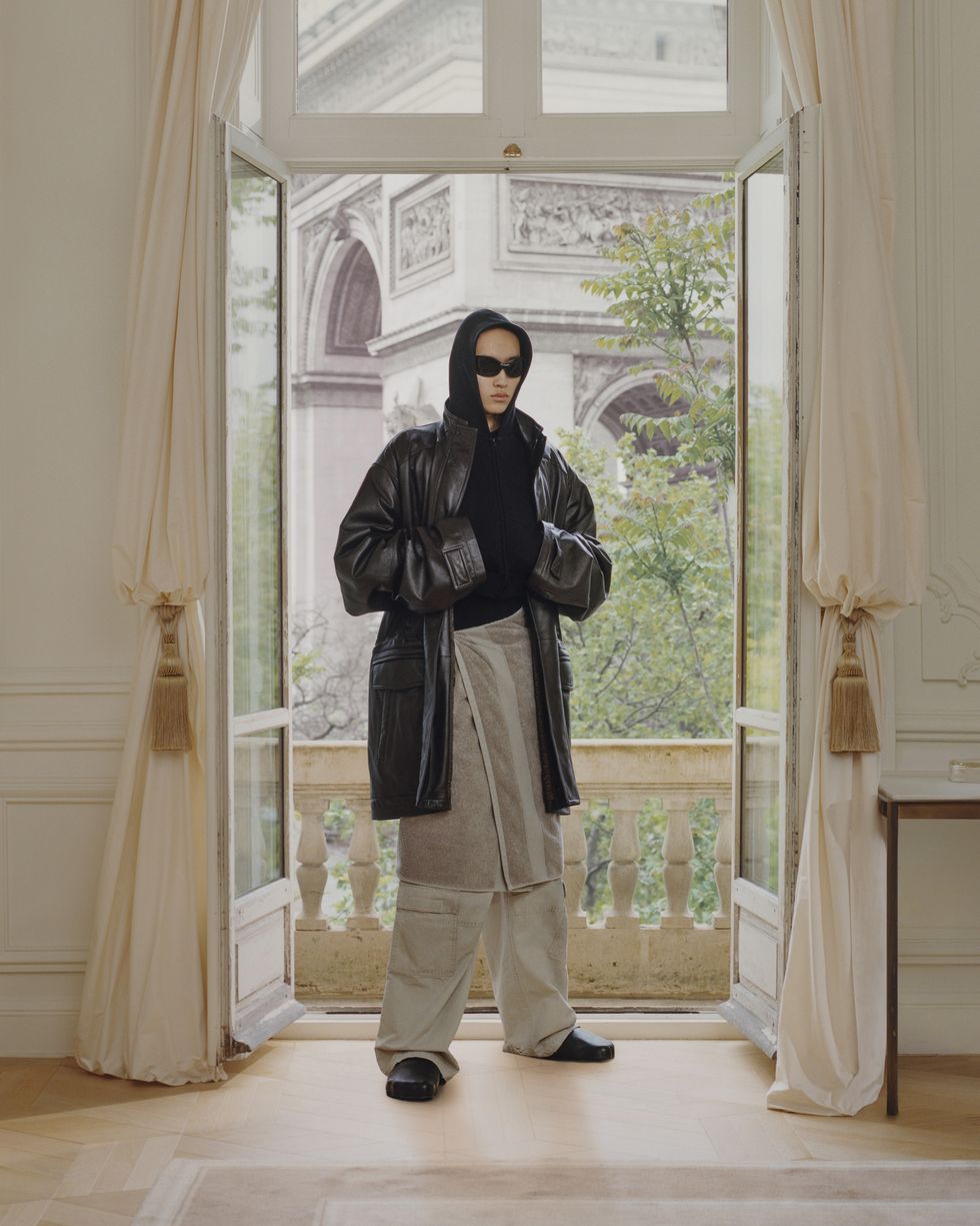 a man wearing a black robe and sunglasses standing in front of a door