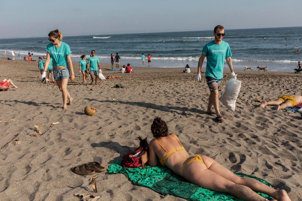 Toeristen helpen met het opruimen van het strand bij Batu Bolong