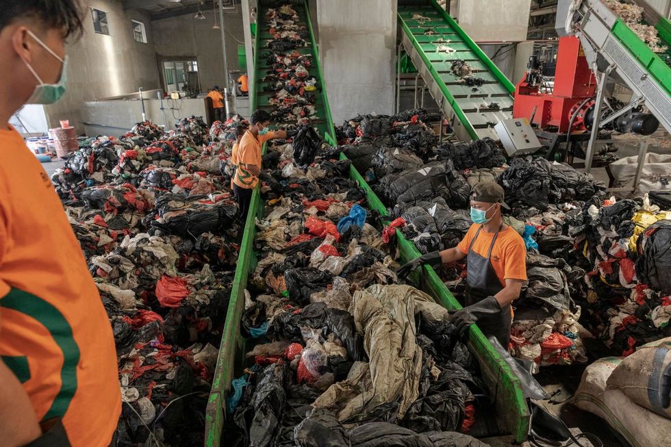 Medewerkers van het bedrijf RePal Recycling in Pasuruan OostJava verzamelen plastic materiaal dat moet worden gereinigd en versnipperd In het bedrijf worden plastic tassen plastic verpakkingen en sommige voedselverpakkingen gerecycled tot plastic pallets die maximaal een ton kunnen dragen