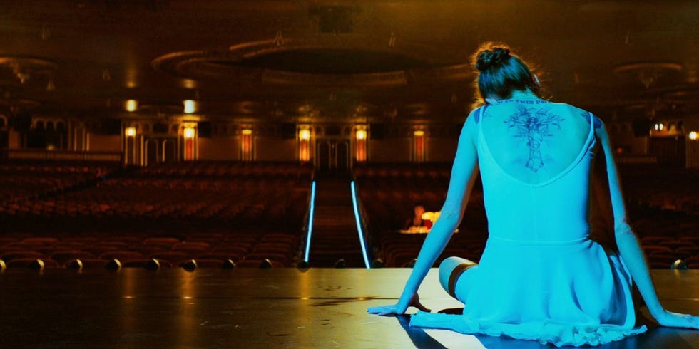 a ballerina sitting on a stage