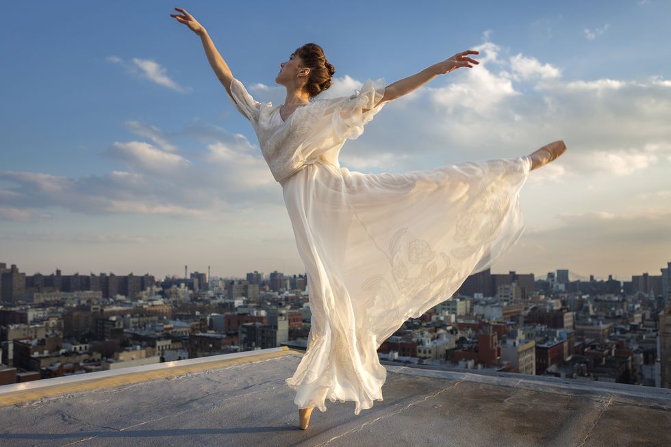ballerina performing arabesque on roof