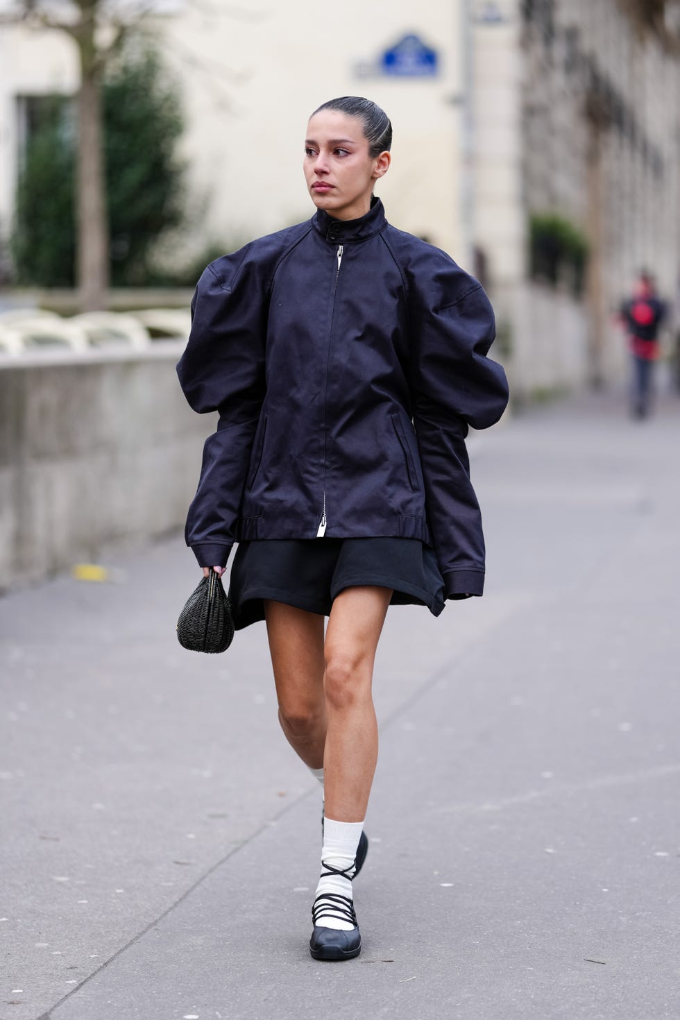 Street Style - Paris Fashion Week - Menswear Fall Winter 2025/2026 - Day Six paris, france january 26: a guest wears black puffy long sleeve sacai shirt, black mini sacai skirt, black leather sacai bag, white socks, black laced up ballerina leather shoes, outside sacai, during the paris fashion week men’s fall/winter 2025 2026 on january 26, 2025 in paris, france. (photo by edward berthelot/getty images)