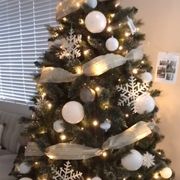 white balloons on a christmas tree with white ribbon, white snowflakes, and glass white ornaments