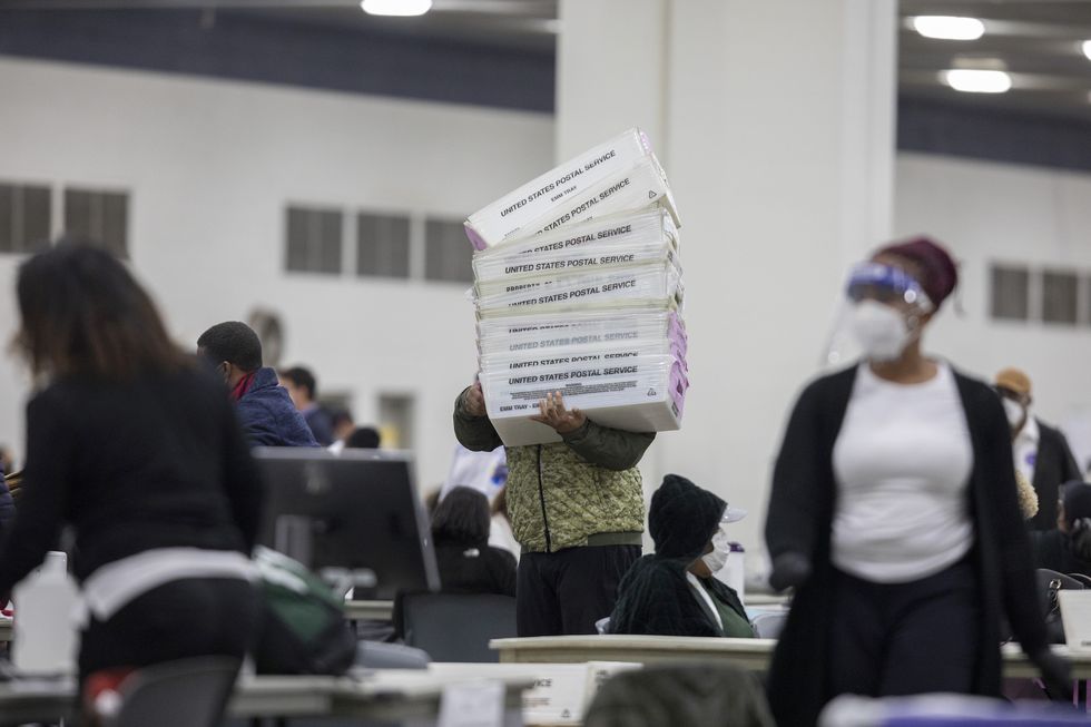 detroit, mi   november 04 a worker with the detroit department of elections carries empty boxes used to organize absentee ballots after nearing the end of the absentee ballot count at the central counting board in the tcf center on november 4, 2020 in detroit, michigan president trump narrowly won michigan in 2016, and both he and joe biden campaigned heavily in the battleground state in 2020 photo by elaine cromiegetty images