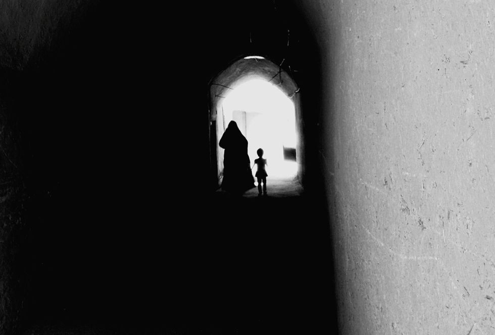Rear View Of Silhouette Mother Walking With Daughter In Tunnel