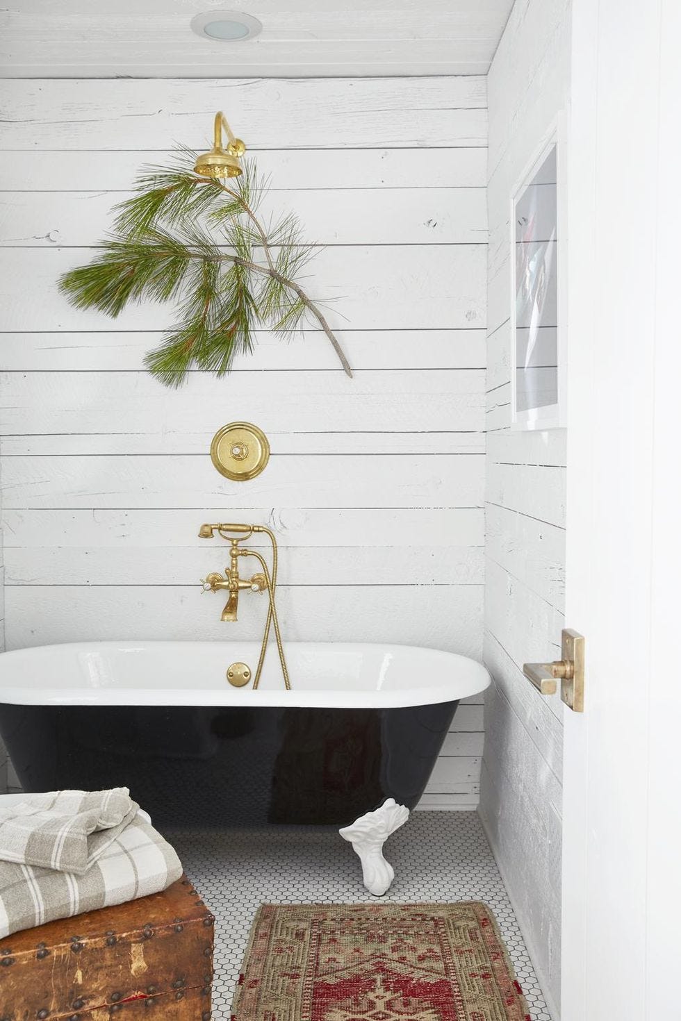 un baño en estilo rústico con bañera exenta y decoración vegetal nautral