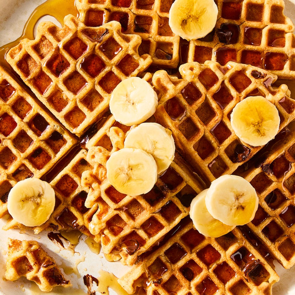 stacked waffles topped with banana slices and syrup