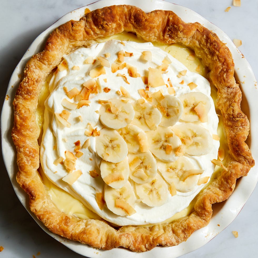 banana cream pie topped with banana slices and toasted coconut flakes