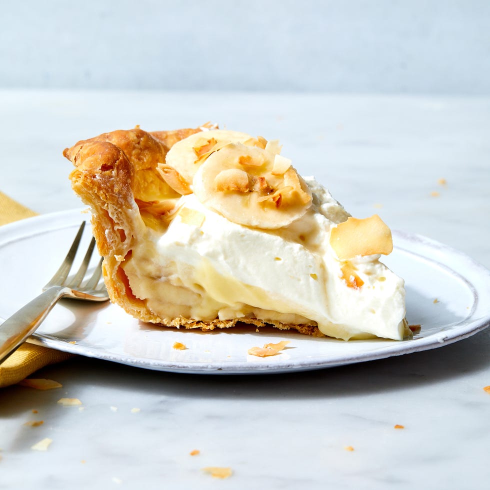 banana cream pie topped with banana slices and toasted coconut flakes
