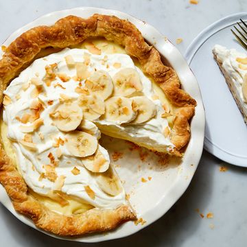 banana cream pie topped with whipped cream, bananas, and toasted coconut flakes