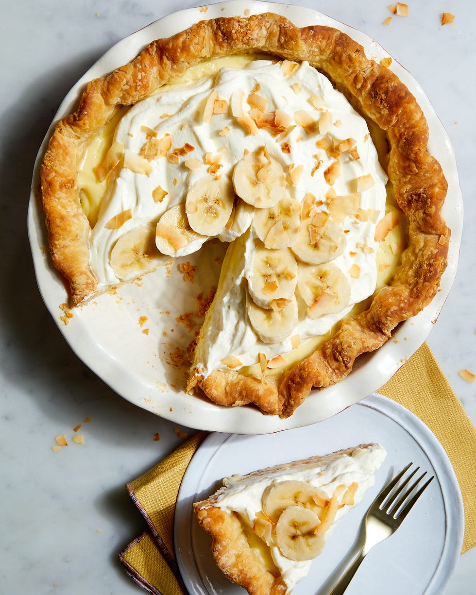 banana cream pie topped with whipped cream, bananas, and toasted coconut flakes