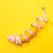 banana wrapped with tape measure on yellow background