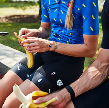 a cyclist eating a banana