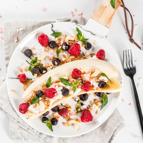 banana cut in half and topped with yogurt, berries, and nuts