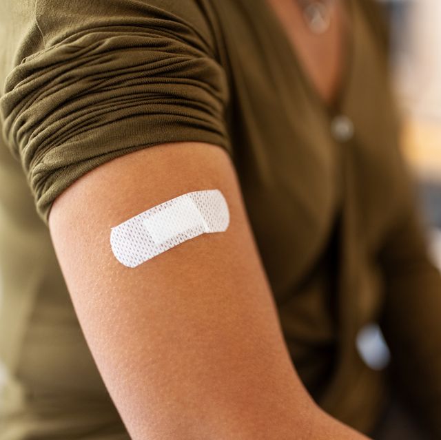 moderna booster, bandage on arm of a female after taking vaccine