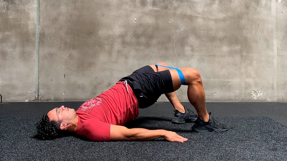 man performs banded glute abduction exercise
