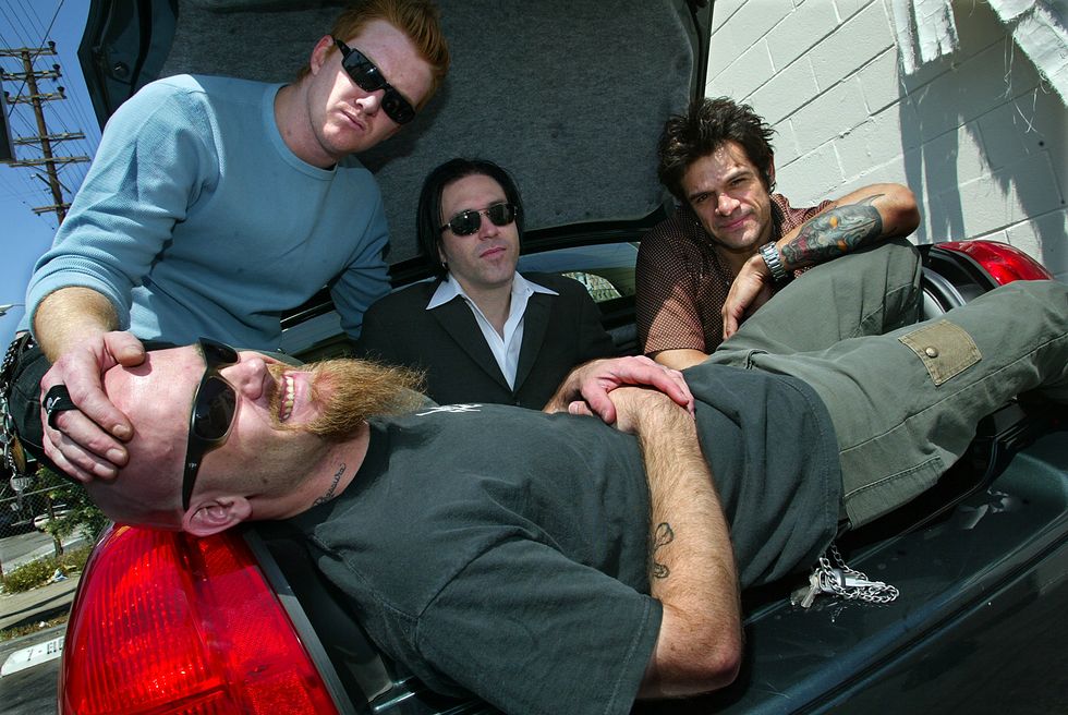 bandmembers of queens of the stone age hitching to coachella, left to right in back are josh homme,