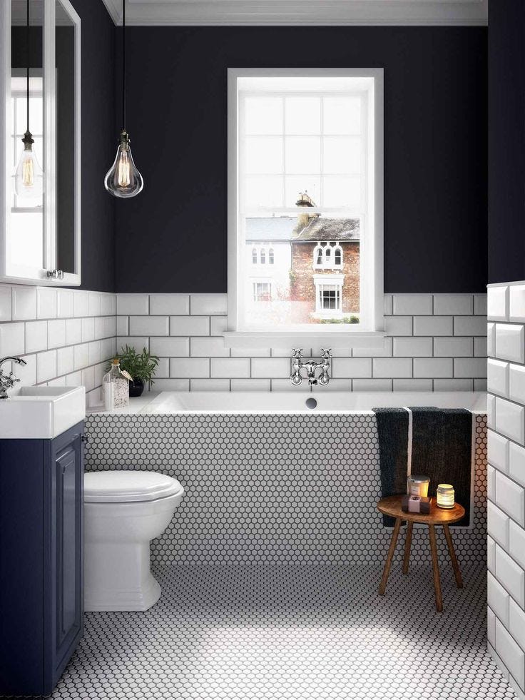 Bañera revestida con un mosaico en tonos blancos y negros