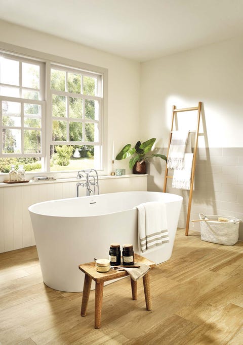 baño con bañera exenta moderna y suelo de madera alena, en surfex®