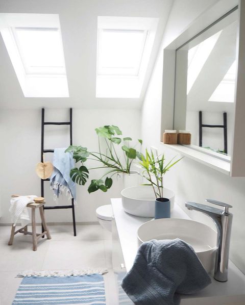 baño moderno blanco abuhardillado con ventanas en el techo