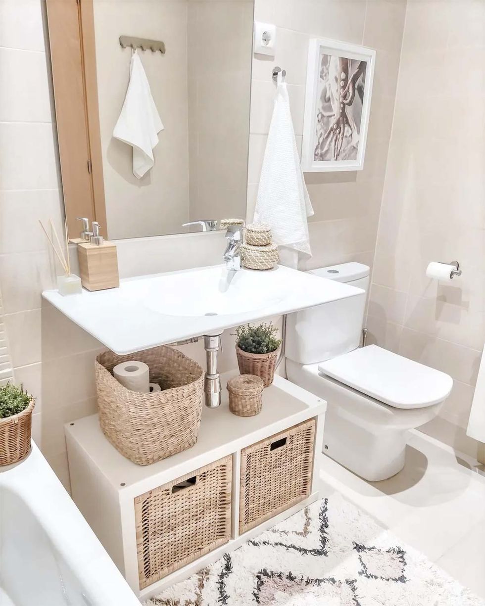 Baño y wc de cerámica con estantería y cesta de mimbre en casa de moda