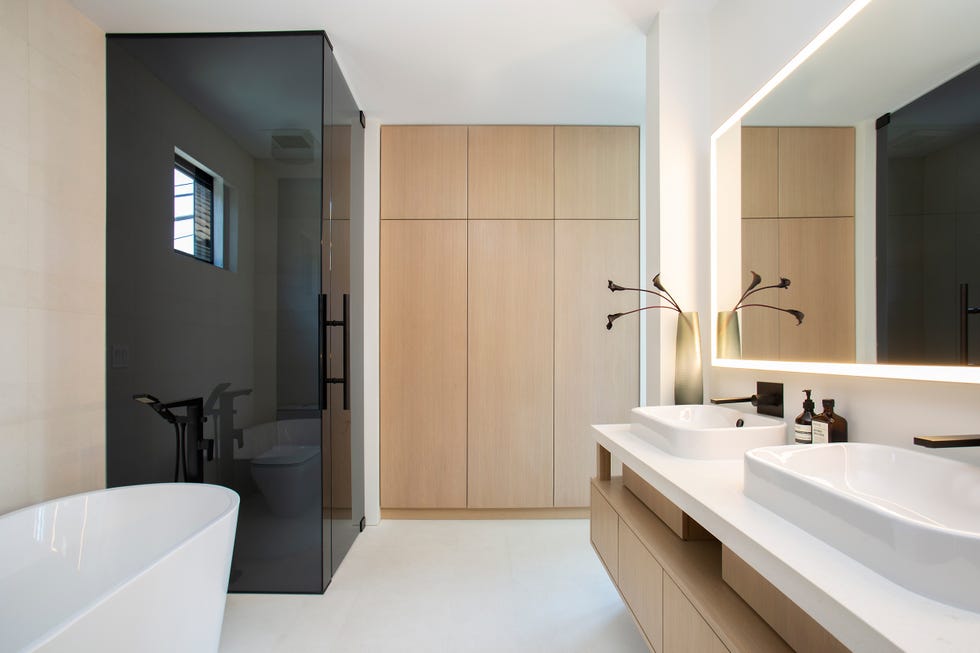 baño con cabina de ducha, mueble de lavabo flotante y armarios empotrados de madera
