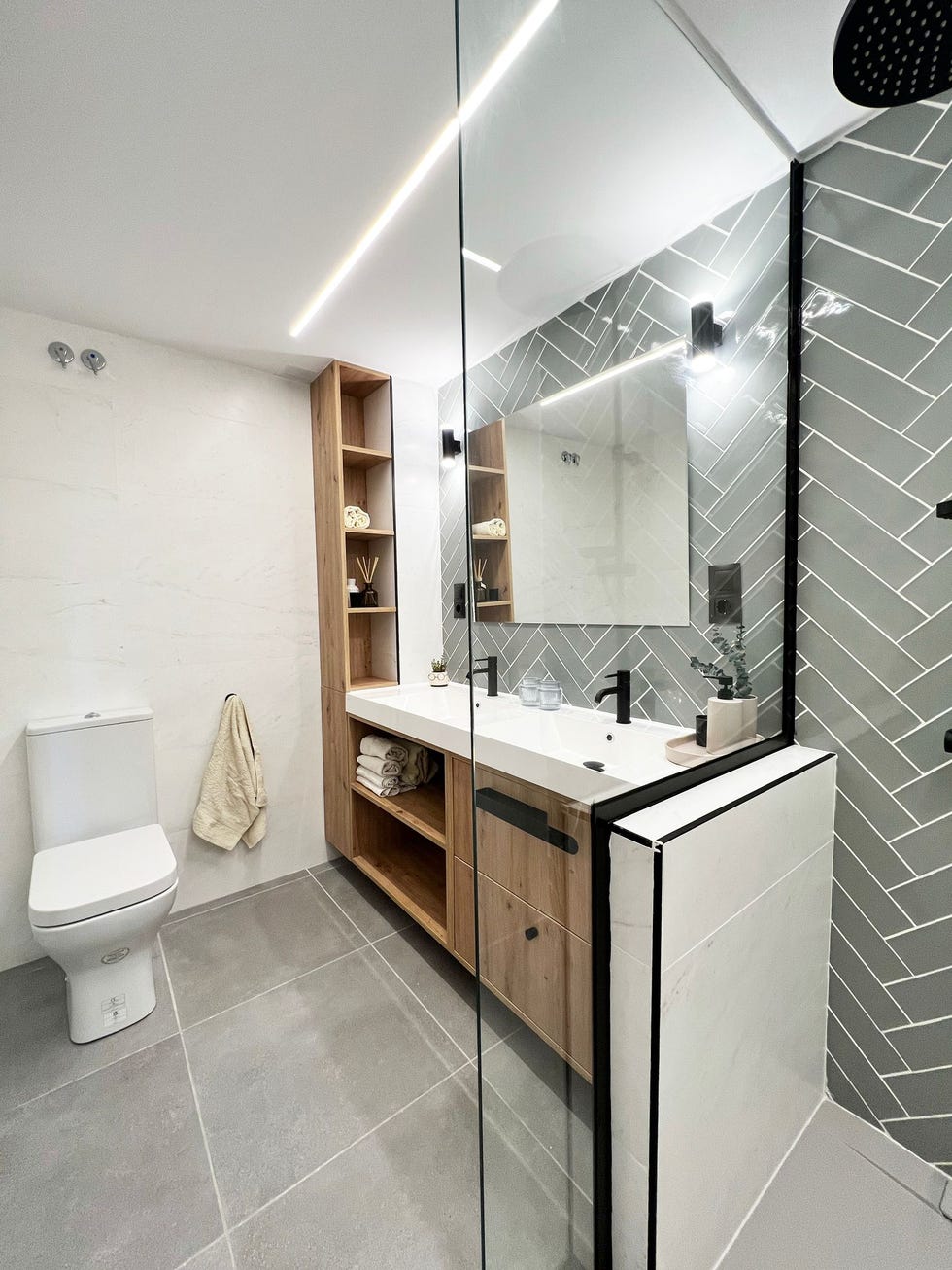 ducha con murete que la separa del mueble de lavabo