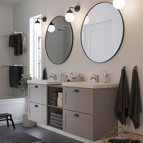 baño gris con lavabo doble y espejos redondos con marco negro