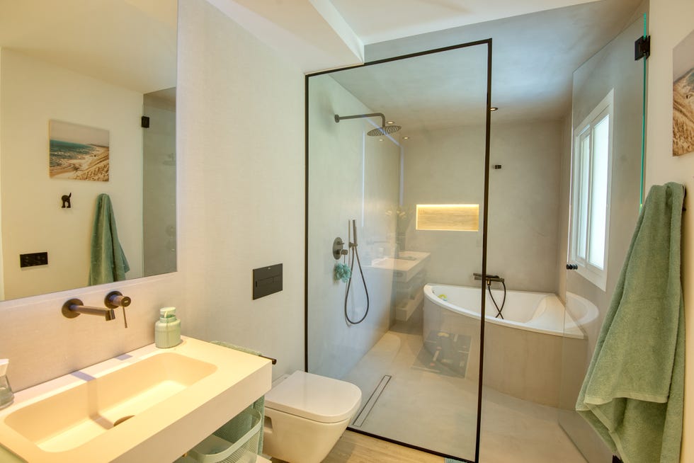 baño revestido en microcemento con bañera y ducha