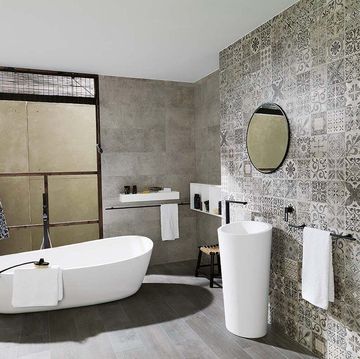 baño moderno con bañera exenta y pared de hidráulicos