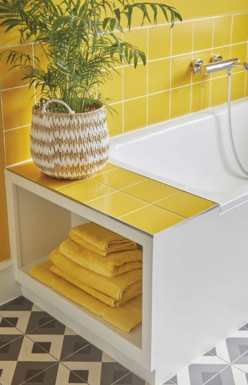 bañera con espacio de almacenaje para toallas azulejos amarillos
