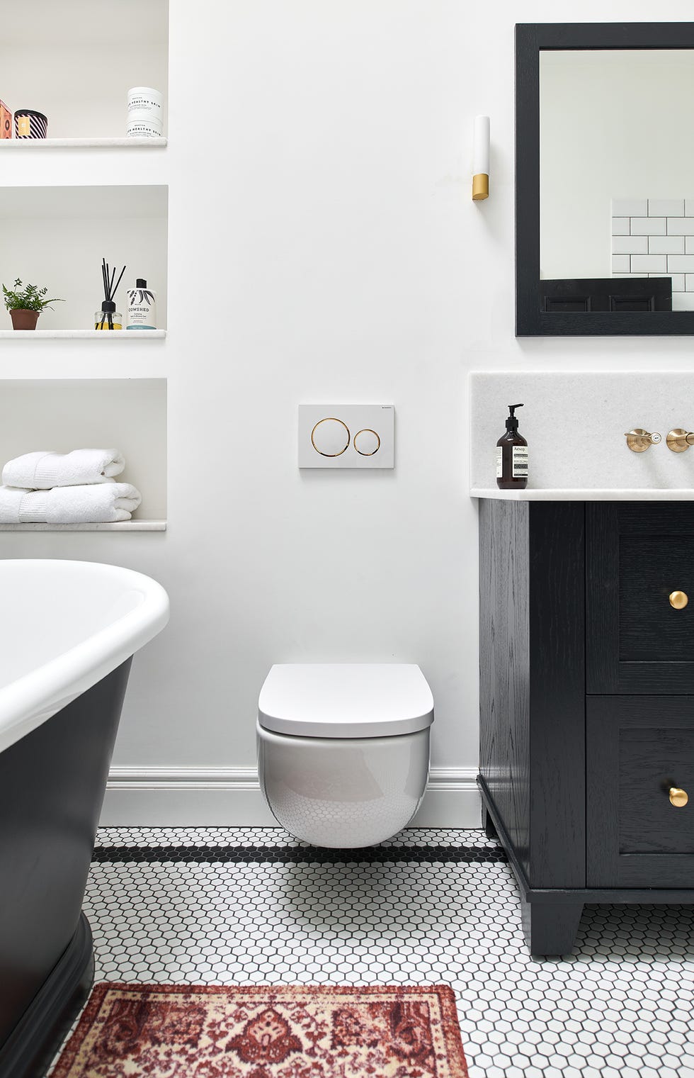 baño decorado en blanco y negro con inodoro suspendido
