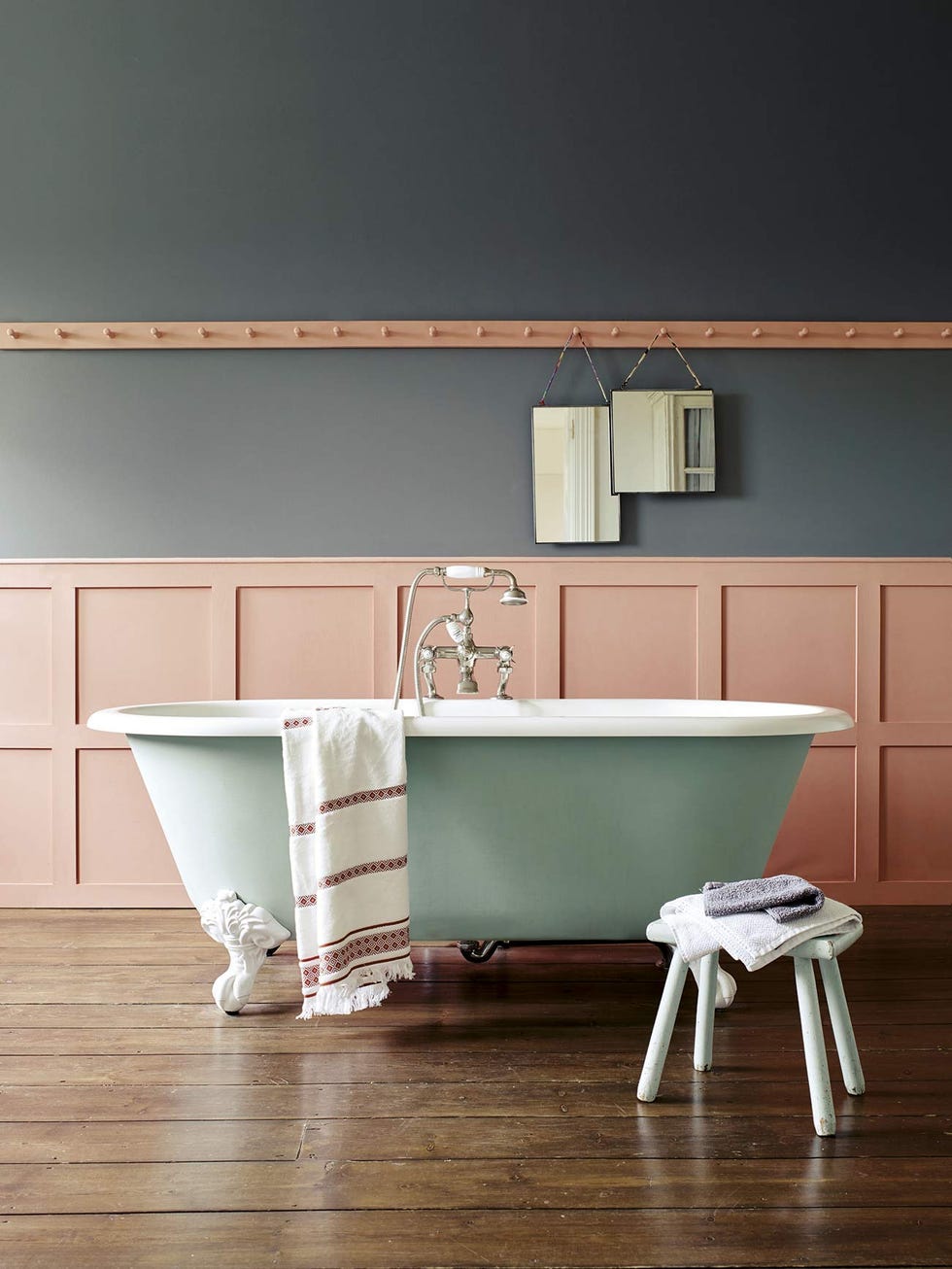 baño pintado en gris y coral con bañera de patas