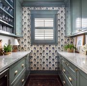 bar with upper and lower cabinets and patterned wallpaper