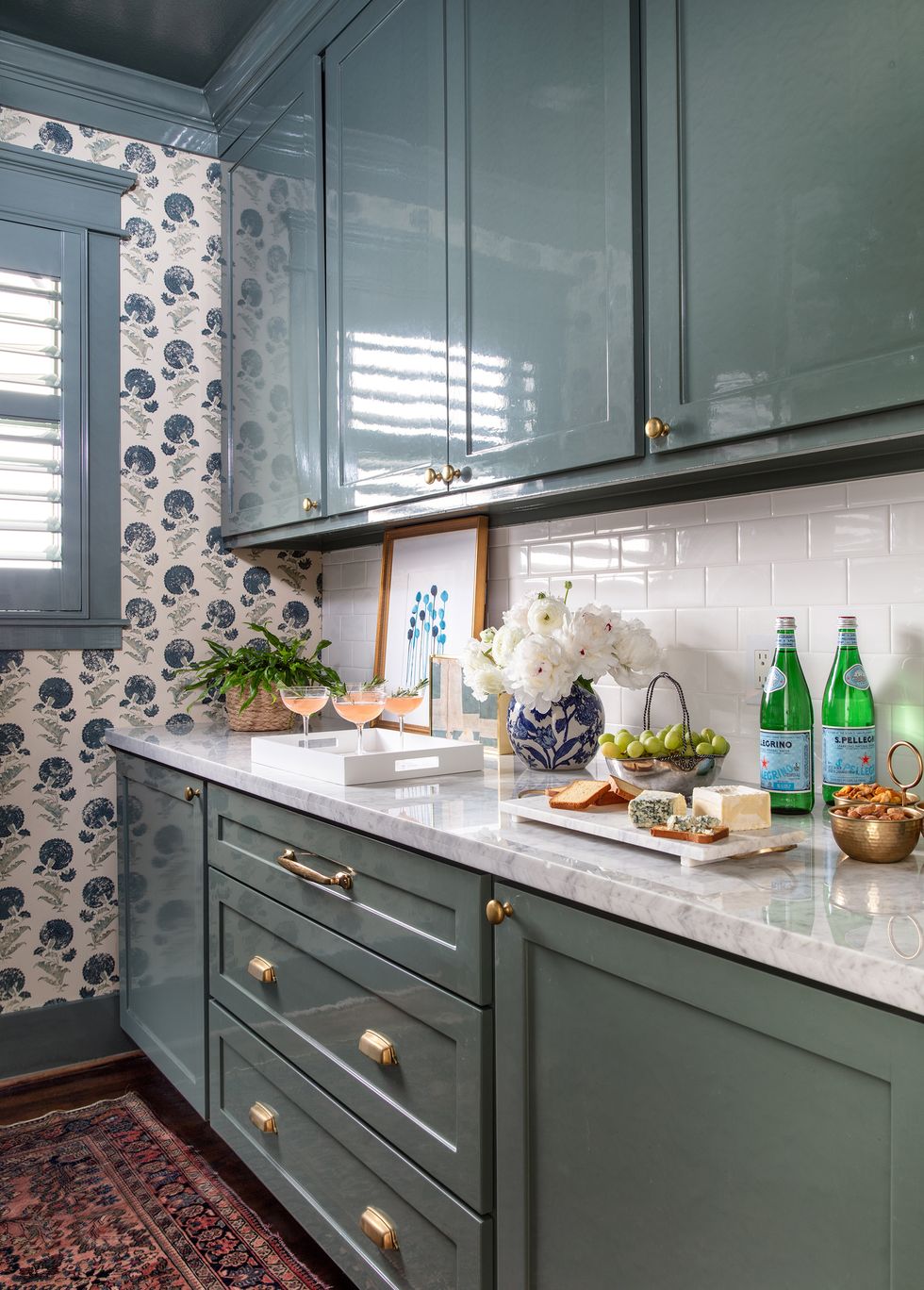 glossy green cabinets and patterned wallpaper