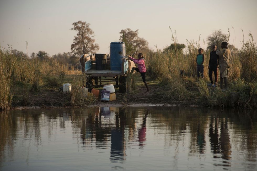 Gezinsleden halen water uit de Okavango in het noordoosten van Namibi Hun boerderij in het KavangoZambezi Transfrontier Conservation Area KAZA ligt in het gebied waarvoor ReconAfrica een vergunning heeft KAZA werd onder meer opgericht ter bescherming van de waterscheiding van de Okavango die in deze droge regio van levensbelang is